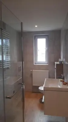 a bathroom with a sink and a toilet and a window at Pokoje do wynajęcia w domku