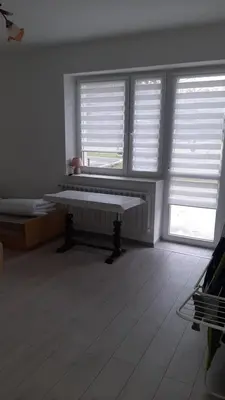 a white room with two windows and a bench at Pokoje do wynajęcia w domku
