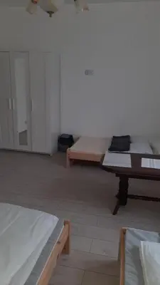 a room with three beds and a table in it at Pokoje do wynajęcia w domku
