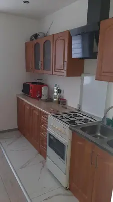 a kitchen with a stove top oven next to a sink at Pokoje do wynajęcia w domku