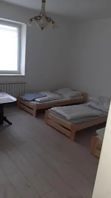 two beds in a room with a window at Pokoje do wynajęcia w domku