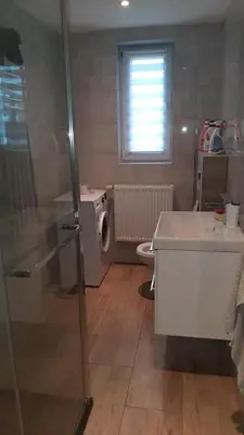 a bathroom with a sink and a washing machine at Pokoje do wynajęcia w domku