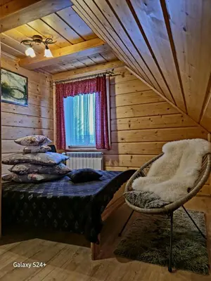 a bedroom with a bed and a window and a chair at Domek pod Babią Górą in Zawoja