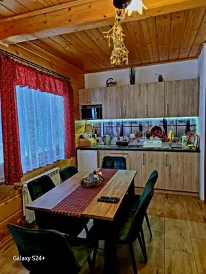 a kitchen with a table and chairs in a room at Domek pod Babią Górą in Zawoja