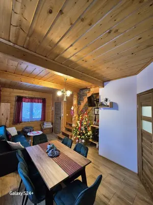 a living room with a table and a christmas tree at Domek pod Babią Górą in Zawoja
