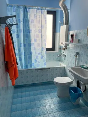 a small bedroom with a bed with a blue bedspread at Aparthotel Na Kasztanowej in Kraków