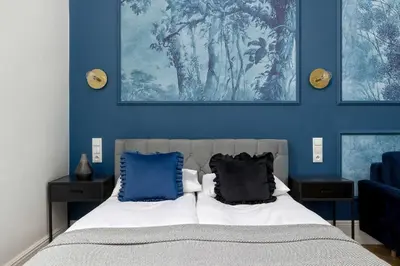 a bedroom with blue walls and a bed with two pillows at Klimatyczne Studio obok Starego Miasta by Noclegi Renters in Kraków