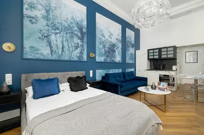 a bedroom with blue walls and a bed and a blue chair at Klimatyczne Studio obok Starego Miasta by Noclegi Renters in Kraków