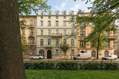 a large building with cars parked in front of it at Klimatyczne Studio obok Starego Miasta by Noclegi Renters in Kraków