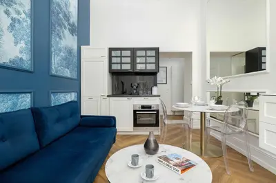 a living room with a blue couch and a table at Klimatyczne Studio obok Starego Miasta by Noclegi Renters in Kraków