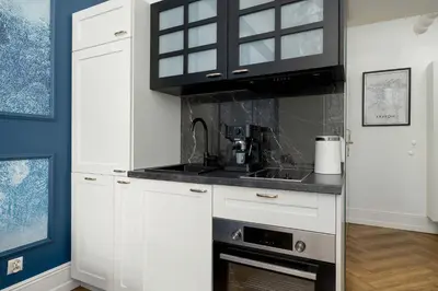 a kitchen with white cabinets and a stove top oven at Klimatyczne Studio obok Starego Miasta by Noclegi Renters in Kraków