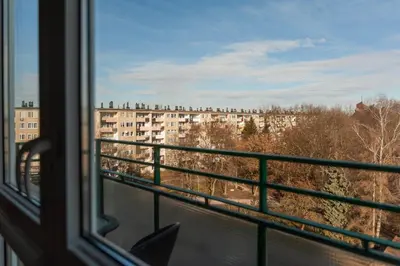 a bedroom with a white bed and a wall at Lan Apartament in Kraków