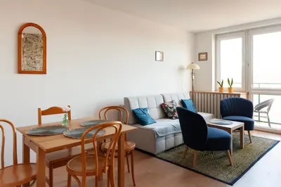 a living room with a television on a dresser and a bedroom at Lan Apartament in Kraków