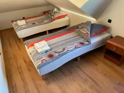 two twin beds in a room with a wooden floor at Zajazd Maj in Bolesław