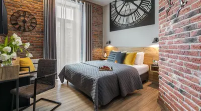 a bedroom with a bed and a brick wall at Art & Garden Residence in Kraków