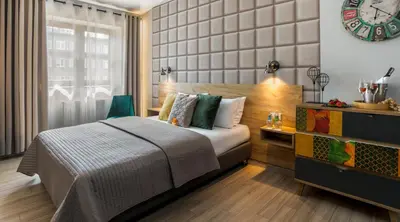 a bedroom with a bed and a clock on the wall at Art & Garden Residence in Kraków