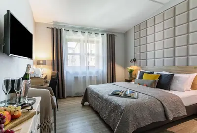 a hotel room with a bed and a table with fruit on it at Art & Garden Residence in Kraków