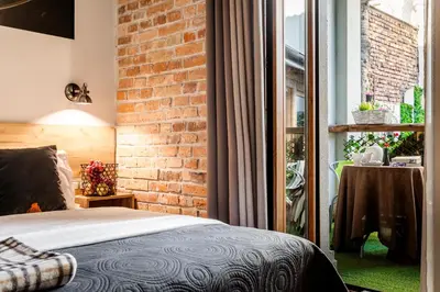 a bedroom with a brick wall and a bed at Art & Garden Residence in Kraków
