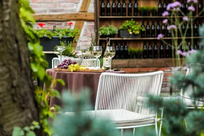 a table with two chairs and wine glasses on it at Art & Garden Residence in Kraków