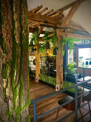 a room with a tree and a table and chairs at Art & Garden Residence in Kraków