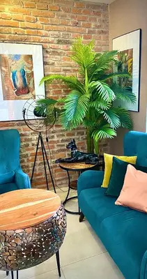a living room with a couch and a plant at Art & Garden Residence in Kraków