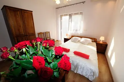 a bedroom with a bed with red roses on it at Willa Julia in Kraków