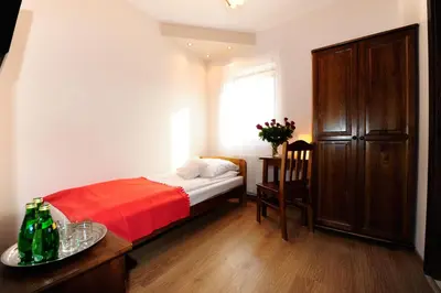 a small bedroom with a bed and a window at Willa Julia in Kraków