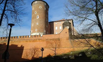 a large brick building with a tall tower on it at AR Apartments in Kraków