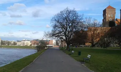 a walkway in a park next to a body of water at AR Apartments in Kraków