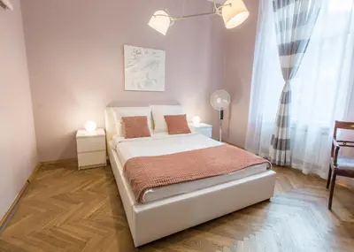 a white bed in a room with a window at AR Apartments in Kraków