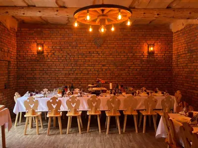 a dining room with tables and chairs and a brick wall at Agroturystyka Sarenka in Podsarnie