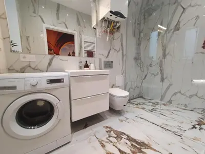 a bathroom with a washing machine and a toilet at FatCat Apartments in Kraków