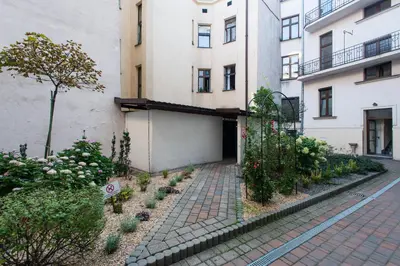 a sidewalk in front of a building with plants at FatCat Apartments in Kraków