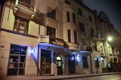 a building on a street at night with lights at FatCat Apartments in Kraków