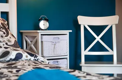 a bedroom with blue walls and a bed and a chair at FatCat Apartments in Kraków