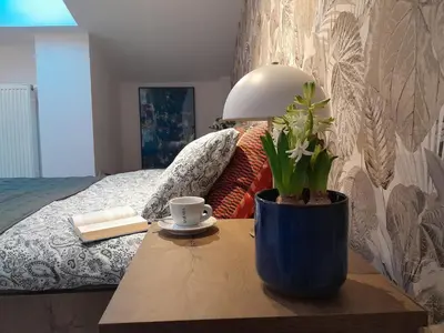 a table with a lamp and a plant on top of a bed at Old Town Premium Apartment Kazimierz - Synagogue view in Kraków