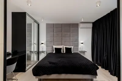 a bedroom with a black bed and a large mirror at Diamonds Apartment in Kraków