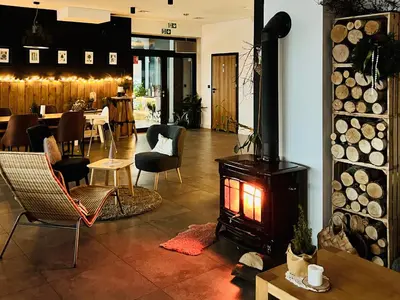 a living room with a fireplace and a dining room at Zagroda na Pacanach in Iwkowa