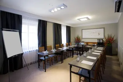 a conference room with tables and chairs and a white screen at Benefis Boutique Hotel in Kraków