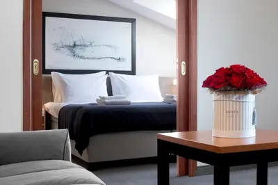 a hotel room with a bed and a table with roses at Benefis Boutique Hotel in Kraków