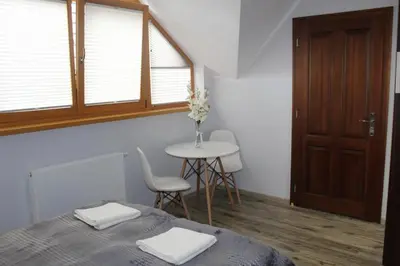 a bedroom with a bed and a table and a window at Gospodarstwo Agroturystyczne Watra in Koninki