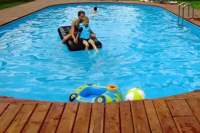 a man and a boy in a swimming pool at Gospodarstwo Agroturystyczne Watra in Koninki