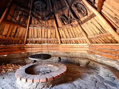 a room with a fire pit in a wooden building at Gospodarstwo Agroturystyczne Watra in Koninki