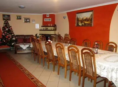 a dining room with a table and chairs and a christmas tree at Gospodarstwo Agroturystyczne Watra in Koninki