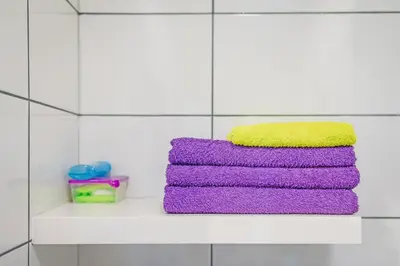 a stack of towels on a shelf in a bathroom at Apartament Franka in Oświęcim