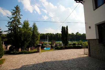a driveway of a house with trees and a building at Willa Zofia in Rabka