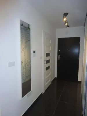 a hallway with a black door and a white wall at Apartament nad Wisłą in Kraków