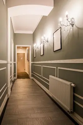 a hallway with green walls and wooden floors and chandeliers at Imagine Apartments in Kraków