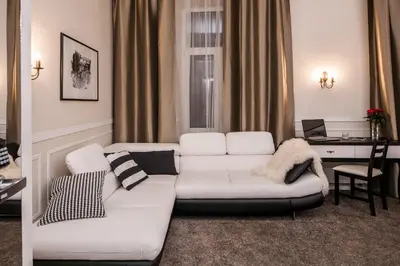 a living room with a white couch and a desk at Imagine Apartments in Kraków