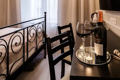 a table with a bottle of wine and two glasses at Imagine Apartments in Kraków